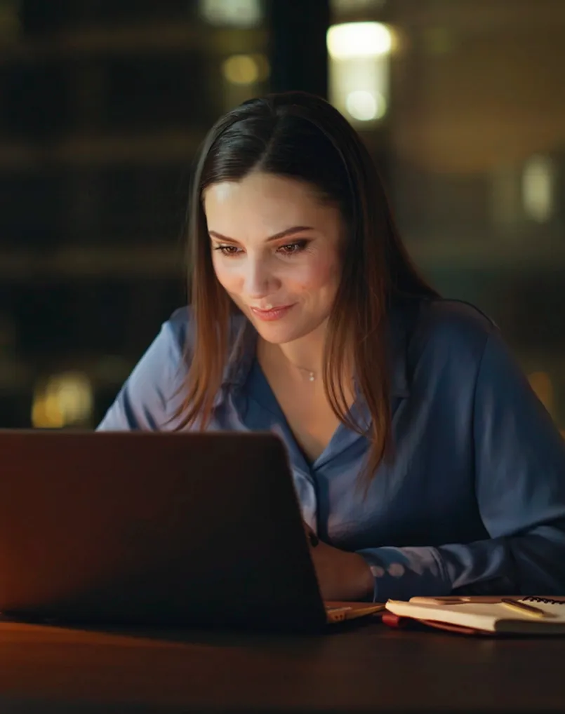 Person smiling at laptop screen